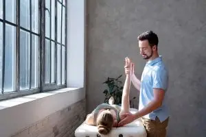 Male therapist performing somatic therapy on a female client to release past life and ancestral trauma stored in the body