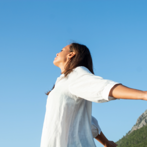 Woman feeling free and rejuvenated through Somatic Therapy in a serene setting