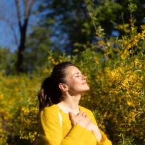Woman with one hand on her chest, reflecting the emotional weight of parentification and carrying too much too young.